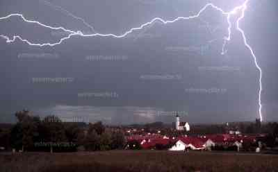 Gewitter - Naturschauspiel in Bayern: Blitze zucken zusammen mit einem Regenbogen am Abendhimmel, Wolkenblitze schlängeln sich durch einen Regenbogen am Abend, kräftige Blitzshow: Gewitter und Unwetter zeigen ihre schönen Seiten, ab Montag drohen wieder Unwetter